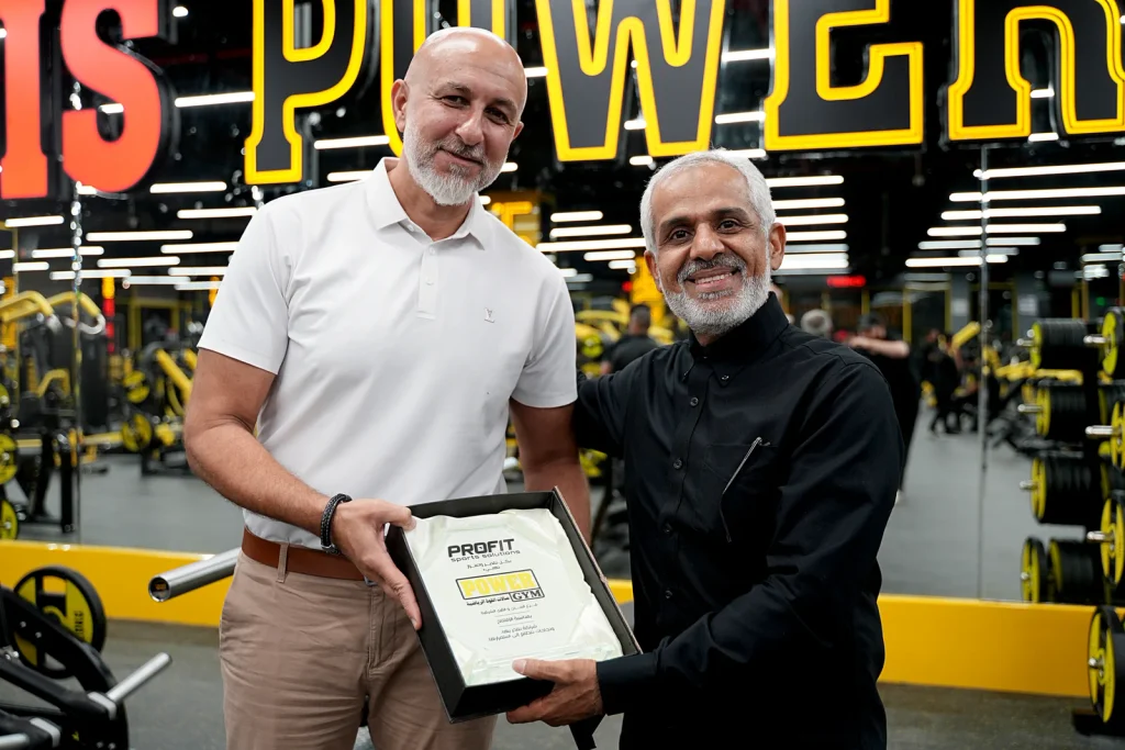 Profit Sports Solutions and Power Gym representatives holding a commemorative plaque at the Power Gym Al Ahsa opening